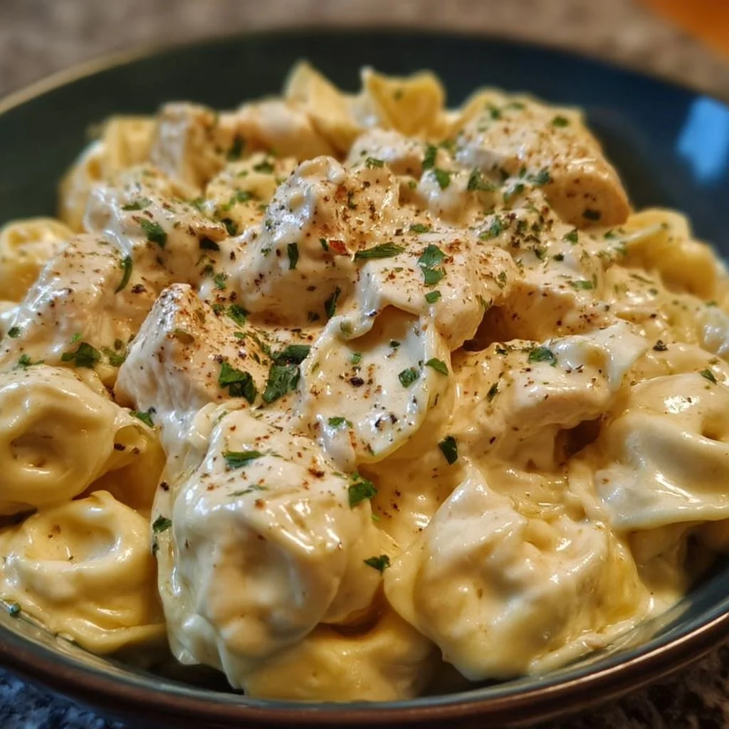 Creamy crockpot chicken alfredo tortellini served with parsley garnish