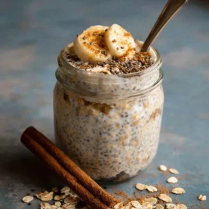 Bowl of cinnamon overnight oats with chia seeds topped with fresh fruit