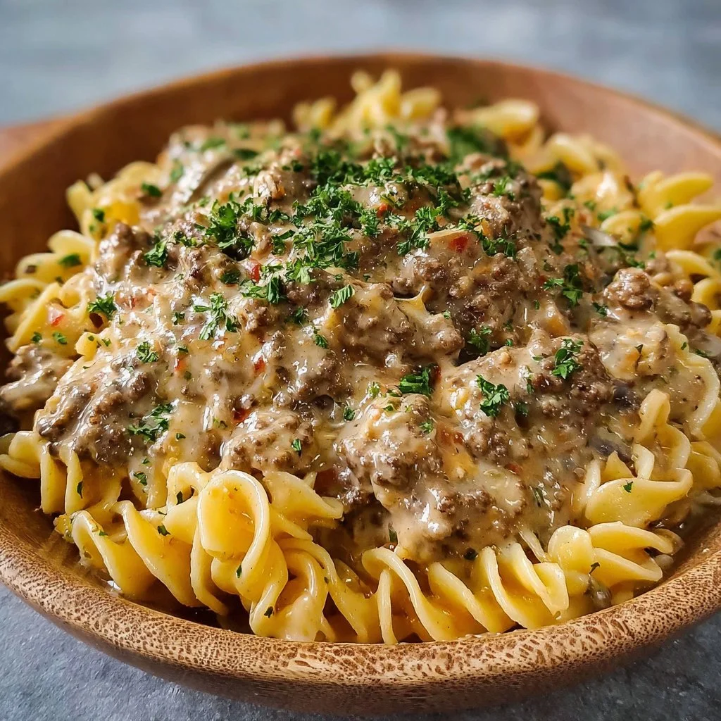 Creamy ground beef stroganoff served on a plate with pasta and parsley garnish