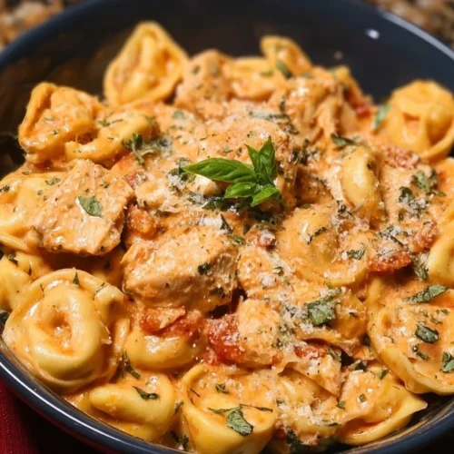 CrockPot Chicken Tortellini in a bowl, garnished with herbs.