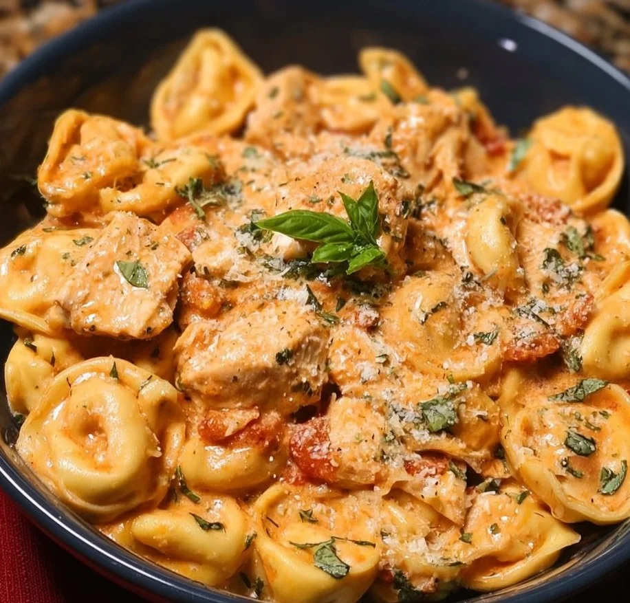 CrockPot Chicken Tortellini in a bowl, garnished with herbs.