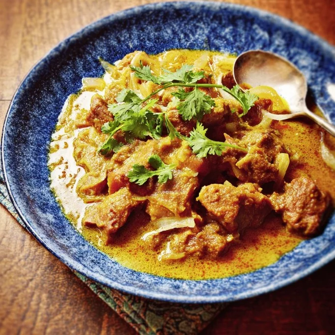Delicious lamb curry garnished with fresh cilantro and spices