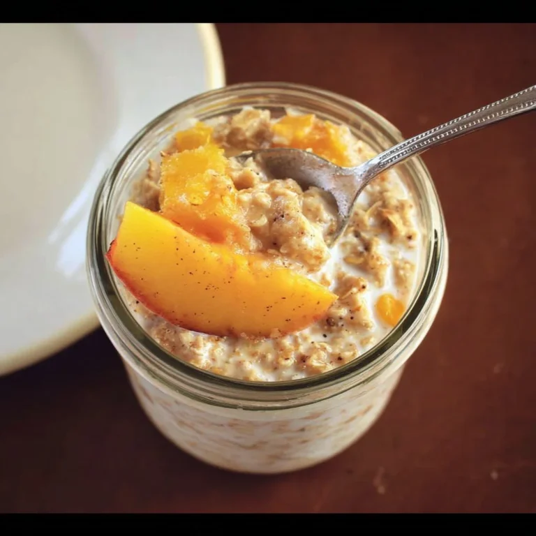 Bowl of Overnight Peach Cobbler Oatmeal topped with fresh peaches and cinnamon