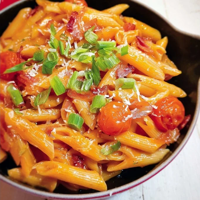 Penne pasta with tomato sauce, pancetta, basil, and pine nuts on a plate