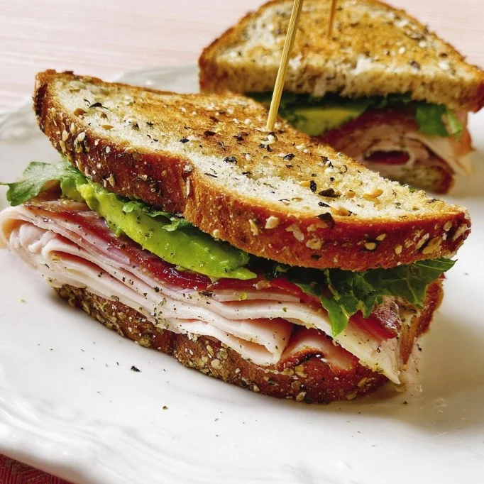 Turkey-Avocado Sandwiches with fresh ingredients on a cutting board
