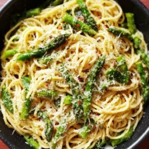 Delicious plate of asparagus pasta topped with Parmesan cheese.