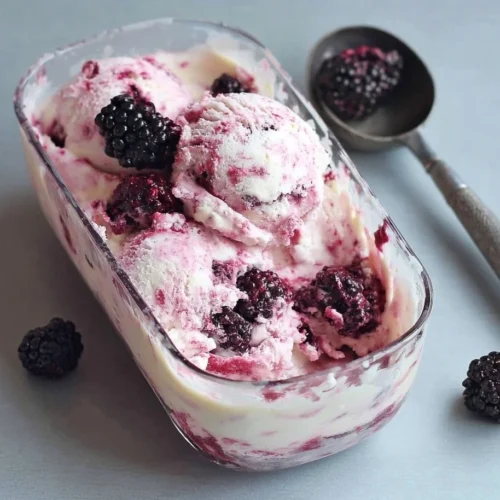 Homemade blackberries and cream ice cream in a bowl with fresh berries on top