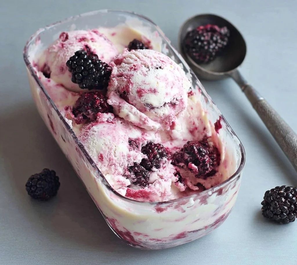 Homemade blackberries and cream ice cream in a bowl with fresh berries on top