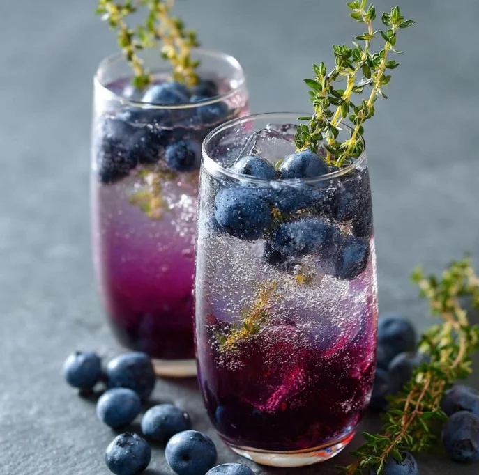 Blueberry Thyme Gin Fizz cocktail garnished with fresh blueberries and thyme