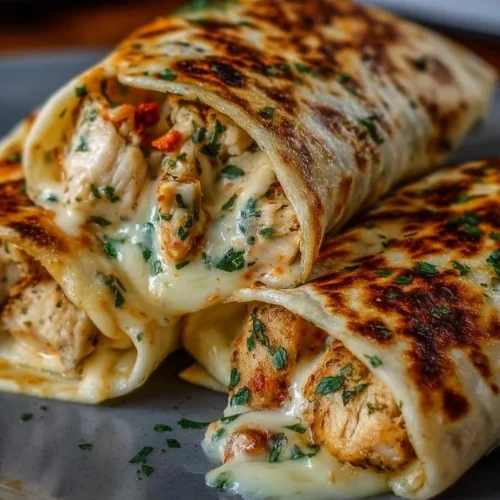 Low carb cheesy garlic chicken wraps garnished with fresh herbs on a plate.