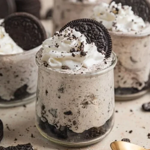 Oreo no-bake cheesecake cups topped with cookie crumbles