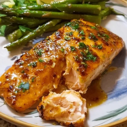 Air Fryer Honey Mustard Salmon Air fryer honey mustard salmon plated with herbs and lemon.