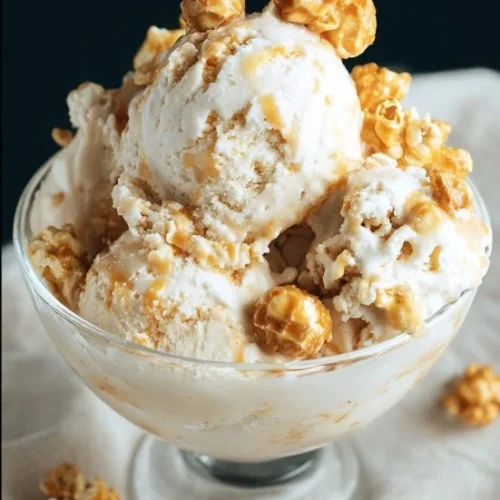 Caramel popcorn crunch ice cream in a bowl, topped with caramel drizzle