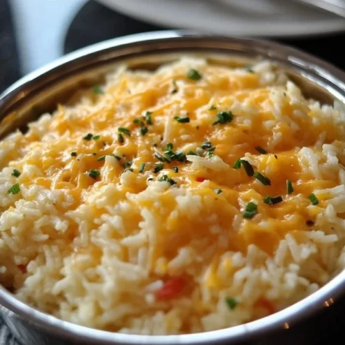 Bowl of cheesy rice with melted cheese and herbs