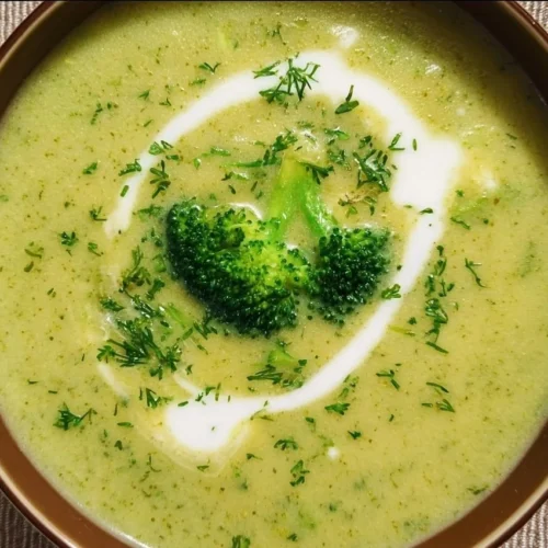 Creamy Broccoli Soup with Potatoes and Cream Bowl of creamy broccoli soup with potatoes and cream, garnished with herbs