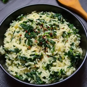 Bowl of creamy spinach rice garnished with fresh herbs