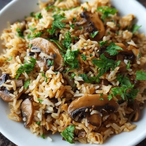 Delicious mushroom rice dish garnished with fresh herbs on a plate.