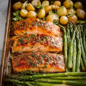 Sheet pan with Maple Dijon Glazed Salmon and colorful vegetables.