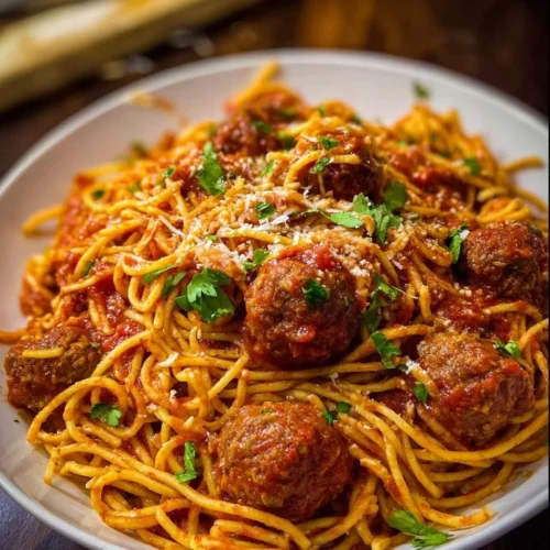 Spaghetti and Meatballs A delicious plate of spaghetti and meatballs garnished with parsley and parmesan cheese.