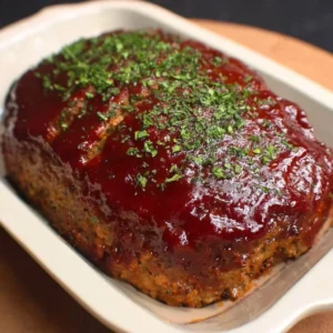 Slice of Granny's classic meatloaf on a plate with vegetables