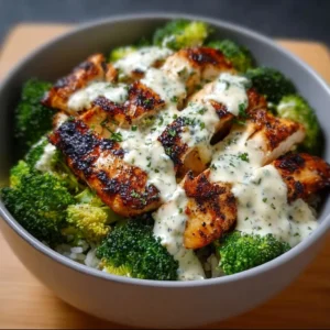 Grilled chicken broccoli bowls topped with creamy garlic sauce.