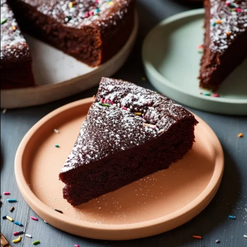Rich Chocolate Ricotta Cake A slice of rich chocolate ricotta cake on a plate with sprinkles.